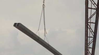 Yük vagonuna bir vinç ile profil borusunu yüklemek, depoya metal yüklemek, büyük bir vinç.