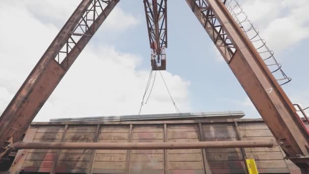 Carregamento de um tubo de perfil por um guindaste de pórtico em um carro de carga, carrega metal em um armazém, um guindaste de pórtico grande — Vídeo de Stock