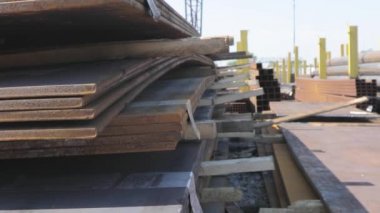 Açık gökyüzünün altındaki metal bir skala üzerindeki metal levhalar, iyi hava, arka planda kanatlı vinç olan metal levhalar, metal ürünler deposu, metal ürünler.