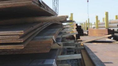 Açık gökyüzünün altındaki metal bir skala üzerindeki metal levhalar, iyi hava, arka planda kanatlı vinç olan metal levhalar, metal ürünler deposu, metal ürünler.