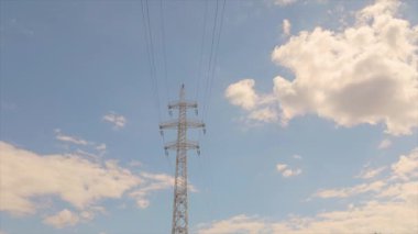 Elektrik taşıma hattı. Yüksek voltajlı kule. Elektrik direklerinin arka planında güzel bulutlar var. Elektrik taşıma hattı. Yüksek voltajlı kule