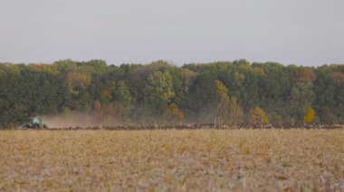 Traktör sahada. Modern bir traktör tarlayı sürer. Yeşil traktör tarlayı sürüyor