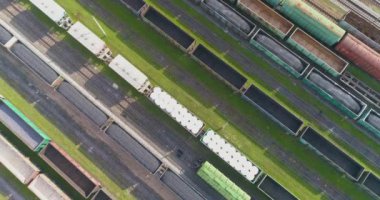 Güneşli havada demiryolu kavşağı, üst manzara. Tren istasyonunun üst manzarasındaki yük trenleri. Demiryolu kavşağındaki yük trenleri