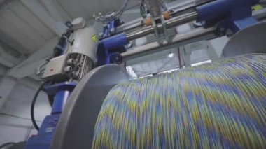 Kablo fabrikası. Yapım aşamasında elektrik kablosunun bobbin kutusuna sarılması. Kablolu yayın. Yakın çekim.