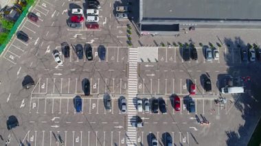 Otopark manzarasında bir sürü araba var. İHA 'nın mağaza görüntüsünün yanına park ediyorum..