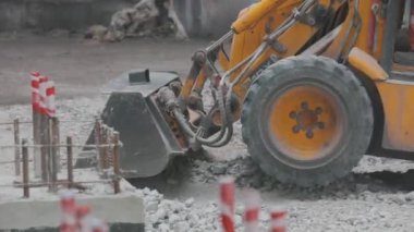 İnşaat alanında buldozer, şantiyede küçük sarı buldozer. Buldozer inşaat alanında çalışıyor.