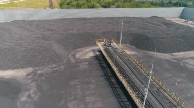 Açık hava deposunun üst manzarasında kola fırını kömürü. Açık hava kömür deposunun üzerinden uçuyor.