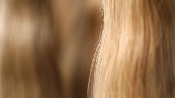 Long hair extensions in the salon close-up. Natural female hair, beautiful female hair. — Stock Video
