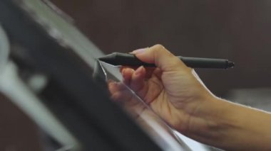 Tasarımcı bir grafik tableti çizer. Etkileşimli kalem ekranıyla çalışıyor. Grafik tableti çiziyorum. Yakın plan. Duvar kağıdı üretimi.