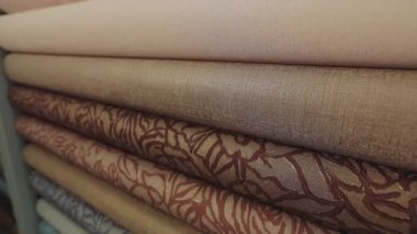 Kalıplı duvar kâğıdı. Duvar kağıdı örnekleriyle birlikte dükkanda duruyor. Yeni örneklerle ayakta duruyor. Duvar kağıdıyla yuvarlanıyor. Yakın çekim.