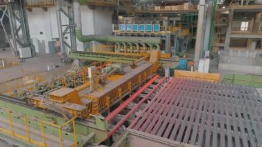 Otomatik metal yuvarlanma hattı. Metal kurusıkı imalatı için atölye çalışması. Endüstriyel iç mekan. Yuvarlanan metal için taşıma hattı, yukarıdan genel bir plan.
