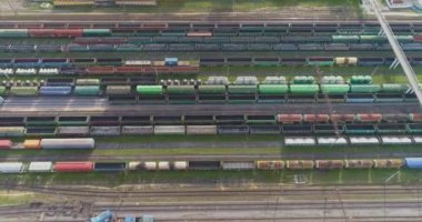 Yük trenleri yukarıdan aşağıya bakıyor. Bir sürü yük treni manzaralı. Tren istasyonunun üzerinde yük trenleriyle uçuyorlar.