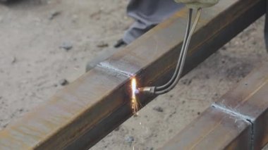 Metal ürünleri gaz kesiciyle kesen işçiler, metal profilini gaz kesiciyle kesiyor, metali yakından kesiyor.
