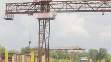 Gangtry vinçle metal ürünleri yüklemek, üretimdeki bir vinç işi, depodaki bir vinç.