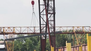 Metal ürünleri vinçle yüklemek, üretimle ilgili bir vincin çalışması, metal ürünlerin depolandığı bir depoda vinç, yakın çekim yapılan bir metal ürünün transferi.