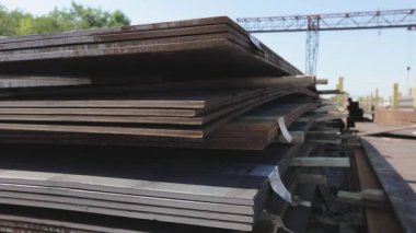 Açık gökyüzünün altındaki metal bir skala üzerindeki metal levhalar, iyi hava, arka planda kanatlı vinç olan metal levhalar, metal ürünler deposu, metal ürünler.