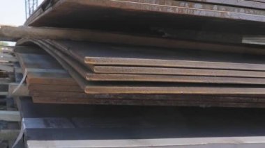 Açık gökyüzünün altındaki metal bir skala üzerindeki metal levhalar, iyi hava, arka planda kanatlı vinç olan metal levhalar, metal ürünler deposu, metal ürünler.