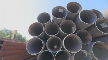 Metal bir depoda büyük çaplı metal borular, açık hava deposunda büyük borular, sıra sıra yığılmış büyük çaplı borular.