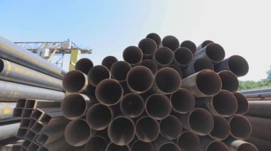 Metal bir depoda büyük çaplı metal borular, açık hava deposunda büyük borular, sıra sıra yığılmış büyük çaplı borular.