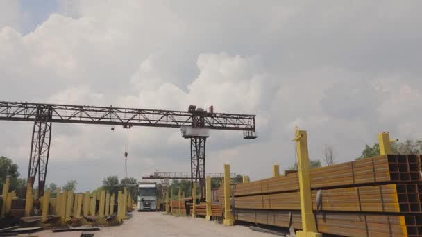 Sebuah derek gantry beban logam ke dalam truk, beban logam di sebuah gudang, derek gantry besar, orang-orang bekerja di sebuah gudang logam — Stok Video