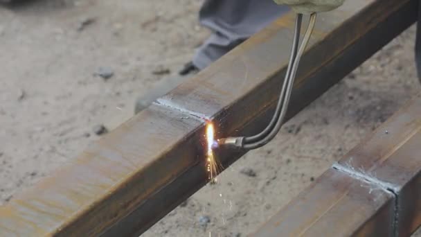 Tagliando prodotti metallici con una taglierina a gas, l'operaio taglia il profilo metallico con una taglierina a gas, taglia il metallo da vicino — Video Stock