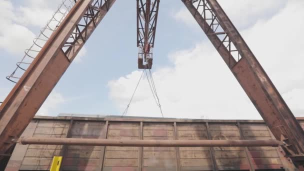 Verladung eines Profilrohres durch einen Portalkran in einen Güterwaggon, Verladung von Metall in eine Lagerhalle, ein großer Portalkran — Stockvideo