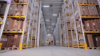 Depoda bir forklift, büyük bir depoda bir adam işi halleder.