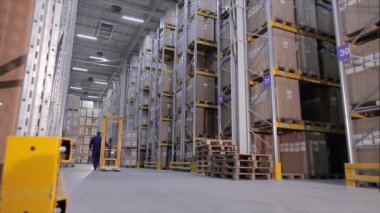 Büyük bir depo işi, iş yerinde depo ekipmanları, büyük bir depoda işçiler.
