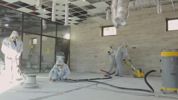 Builders are polishing the floor with special equipment. Concrete surface grinding. Builders at a construction site — Stock Video