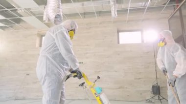 Beton yüzey öğütme. İnşaat alanındaki inşaatçılar. İnşaatçılar zemini özel ekipmanlarla parlatıyorlar..