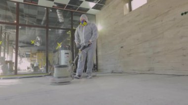 Beton yüzey öğütme. İnşaat alanındaki inşaatçılar. İnşaatçılar zemini özel ekipmanlarla parlatıyorlar..