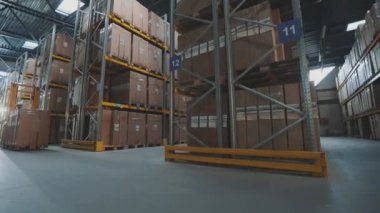 Elektrikli forklifti olan bir işçi. Depoda işçi forklifti var. İşçi depoda yürüyor.