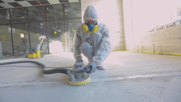 Bouwvakkers. Werkproces op een bouwplaats. Werknemers in beschermende pakken slijpen de betonnen vloer. Werknemers maken betonnen vloer — Stockvideo