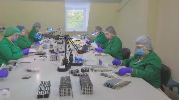 Factory workers pack pills. Masked workers. Workflow at a pharmaceutical factory — Stock Video