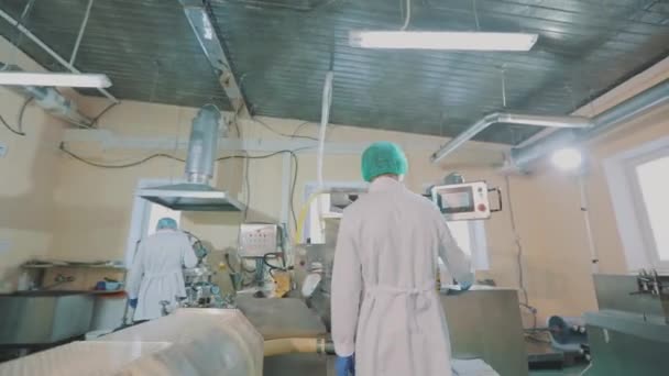 Maskierte arbeiten in einer Fabrik. Arzneimittelherstellungsprozess. In der Pillenwerkstatt. Das Innere der Pharmafabrik. — Stockvideo