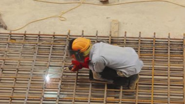 Bir kaynakçı metal bir yapıyı kaynak yapar. Kaynak metal yapımı. Güçlendirilmiş beton takviyesi