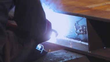 Fabrika kaynakçısı. Fabrikada çalışan bir işçi metal bir yapıya kaynak yapar..