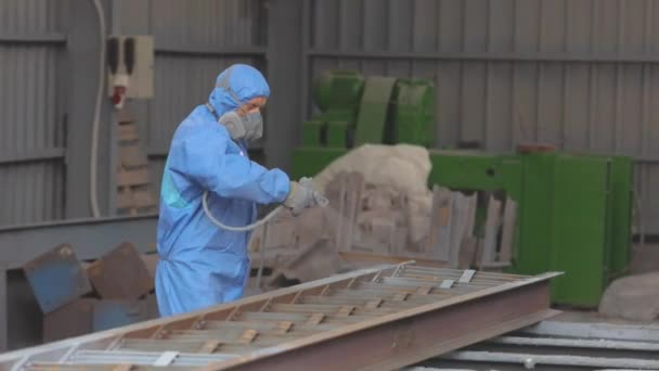 Werknemers in beschermende pakken schilderen een metalen onderdeel. Onderdeel schilderen in de fabriek — Stockvideo