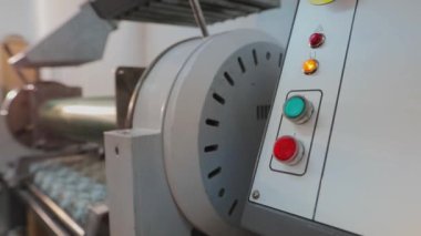 Beyaz adam el ile düğmeye basıyor. Bir adam torpidodaki düğmelere basıyor, kapat. Fabrika süreci duvar kağıtları oluşturur. Duvar kağıtları için oyma oluşturuluyor.