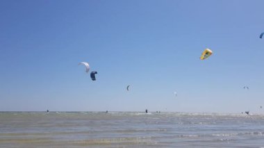 İnsanlar uçurtma sörfü yapıyor. Denizde kaykay yapmak. İnsanlar su üstünde sörf yapar.