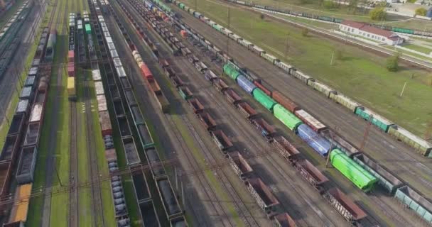 Los trenes se encuentran en un cruce de ferrocarril vista superior. Volar sobre un gran número de trenes de mercancías. Hay muchos trenes en un gran cruce. — Vídeo de stock