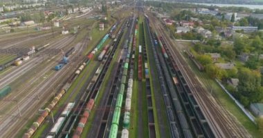 Büyük tren deposu manzaralı. Demiryolu istasyonunda bir sürü renkli tren var.
