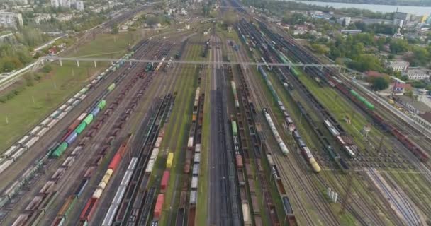 Grand dépôt ferroviaire industriel. Les trains sont garés au dépôt à la jonction ferroviaire. De nombreux trains colorés — Video