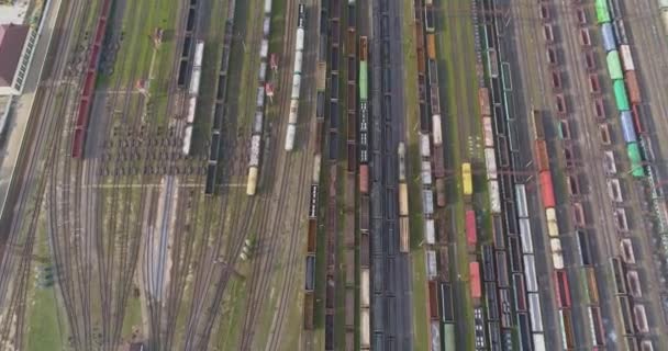 Grande vista aérea da junção ferroviária. Há muitos trens no depósito ferroviário. Depósito com um grande número de linhas ferroviárias e trens de carga — Vídeo de Stock