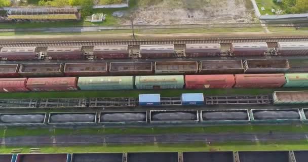 Demiryolu kavşağındaki yük trenlerinin en üst görüntüsü. Yük trenleri ile büyük tren kavşağı manzaralı. İstasyondaki trenlerin üzerinden uçuyor. — Stok video