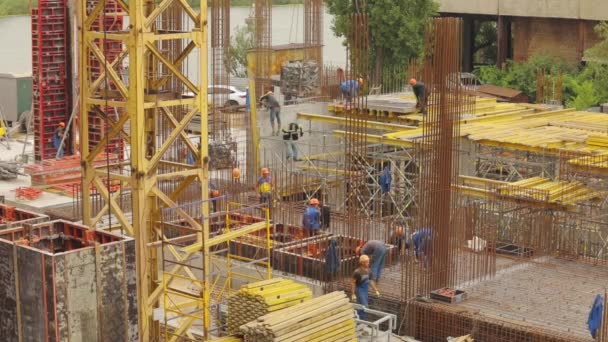 Stahlbetonbau. Arbeiter auf einer Baustelle. Menschen arbeiten am Bau eines neuen Hauses. — Stockvideo