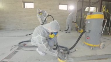 İnşaatçılar zemini özel ekipmanlarla cilalıyorlar. Beton yüzey öğütme. İnşaat alanında inşaatçılar