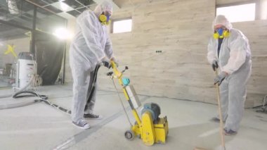 Çizgiye çalış. Üniformalı inşaatçılar. İnşaatçılar beton zemin yapıyorlar. Profesyonel ekipmanlı inşaatçılar