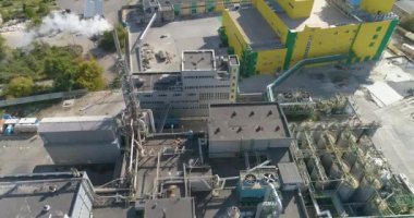 Fabrikanın bacasından duman, modern bir fabrikanın bacasından beyaz duman. Fabrikanın bacasının yanında dumanla uçuyor.