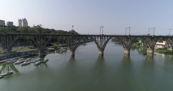 Железнодорожный мост через реку. Мост через реку в большом городе. Полет возле железнодорожного моста через реку в большом городе — стоковое видео